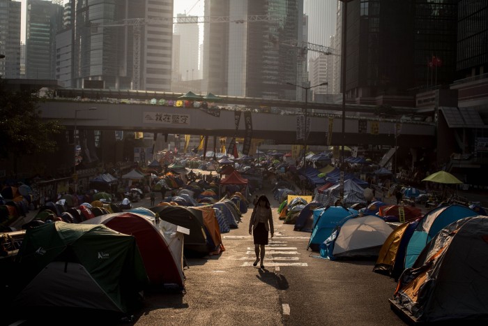 A woman walks to work through the Admiralty protest site on November 18 2014 in Hong Kong