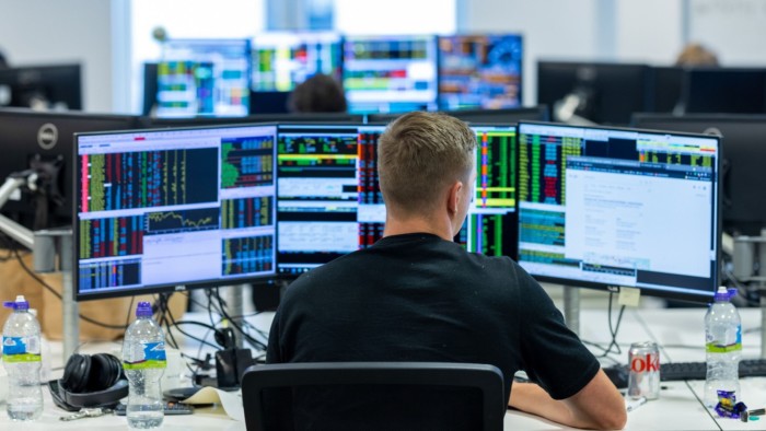 A City trader in front of screens 