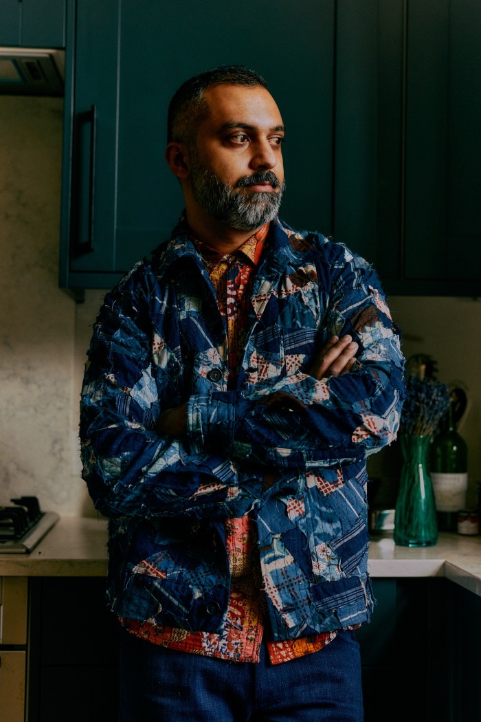 Ajesh Patalay at home. He wears Kardo upcycled cotton Bodhi jacket, £336, upcycled cotton Chintan shirt, £310, and denim Omi jeans, £202