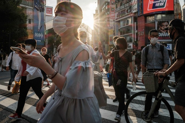 People wear face masks in Tokyo on July 28, 2021