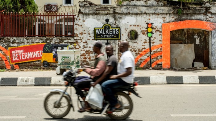 A moto taxi carries two passengers in Lagos, Nigeria