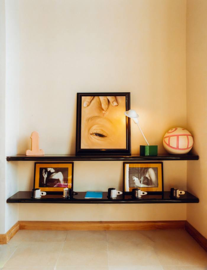 Top shelf, from left: Ettore Sottsass phallic-shaped vase and lamp, artwork by Oda Jaune and Medicom Mr A Ball by Saraiva. Bottom shelf: mugs by Peter Shire and photography by Olivier Zahm 