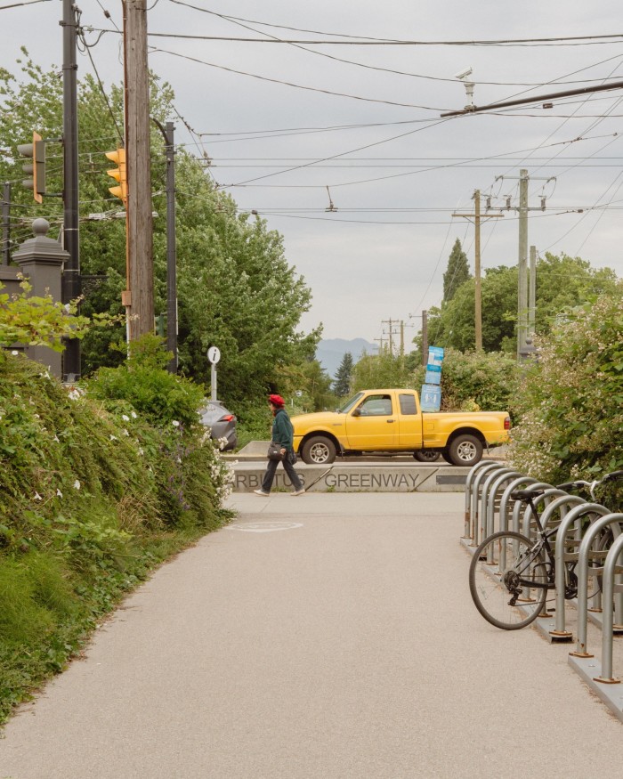 Part of the Arbutus Greenway, with a yellow truck passing by at one of its junctions