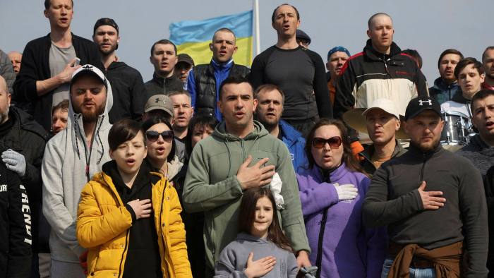 Residents of Odesa sing the national anthem after building a barricade for a checkpoint