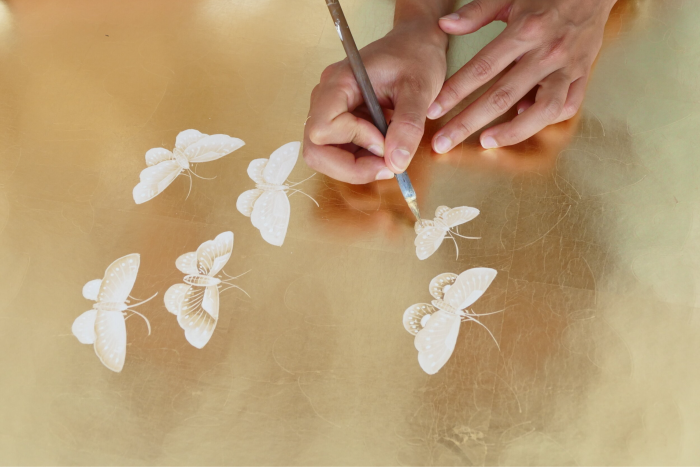 butterfly design being painted on wallpaper