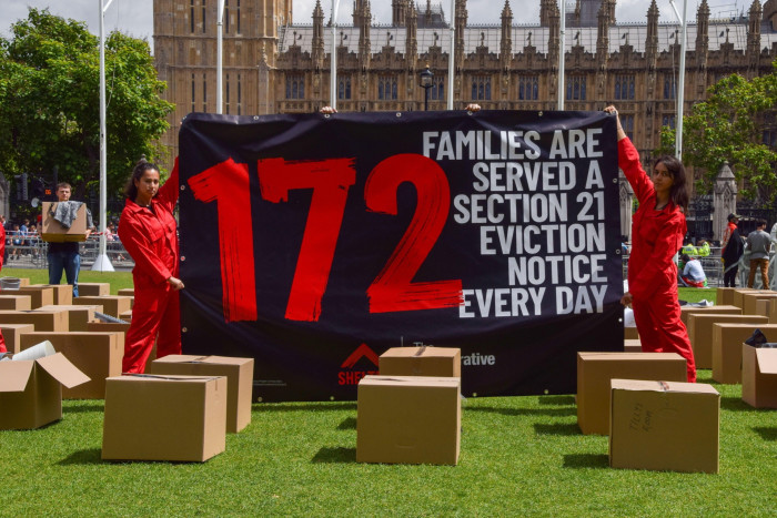 Protesters hold a banner reading ‘172 families are served a Section 21 eviction notice every day’