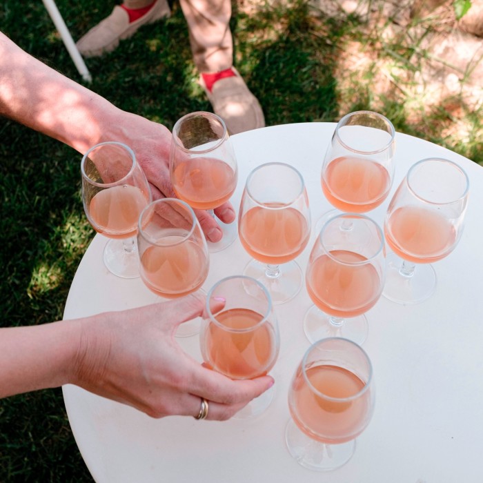 People take glasses of rosé from a tray