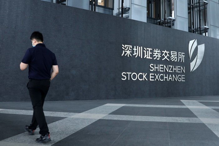 A man walks past the Shenzhen Stock Exchange