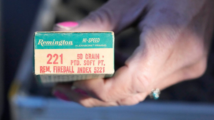 A hand holding a box of Remington ammunition