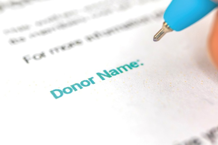a pen hovering over a form saying donor name