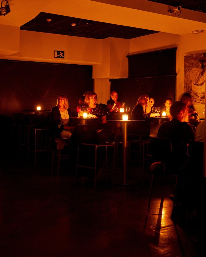  Audience members at candlelit tables in Las Tablas