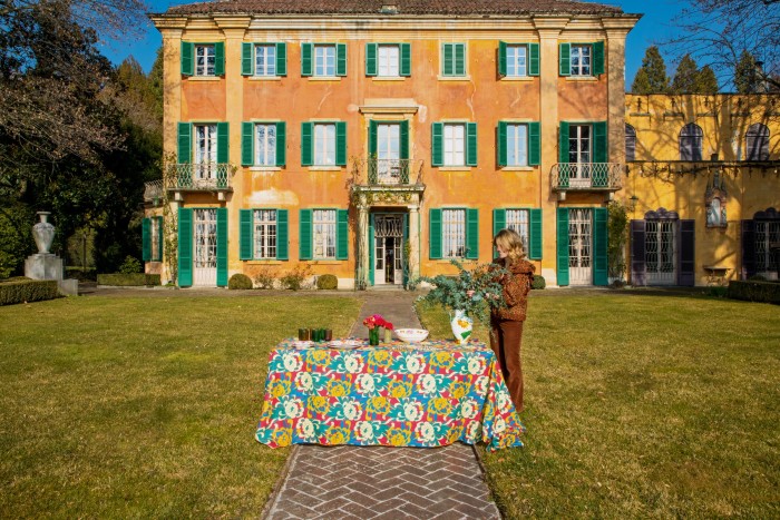 Martina Mondadori, editor-in-chief of Cabana, in the grounds of Villa Silvio Pellico with the Dahlia tablecloth, £280, and other Artigiana pieces