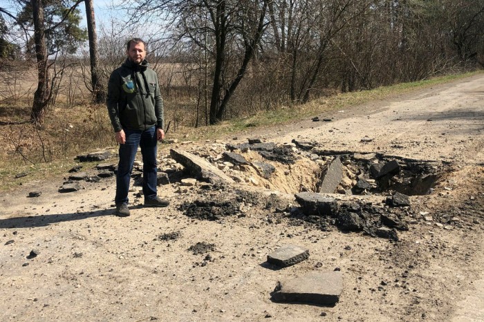 Dmytro Lysovyy stands by a crater at the location of a Ukrainian military strike on a Russian armoured convoy in Hostomel