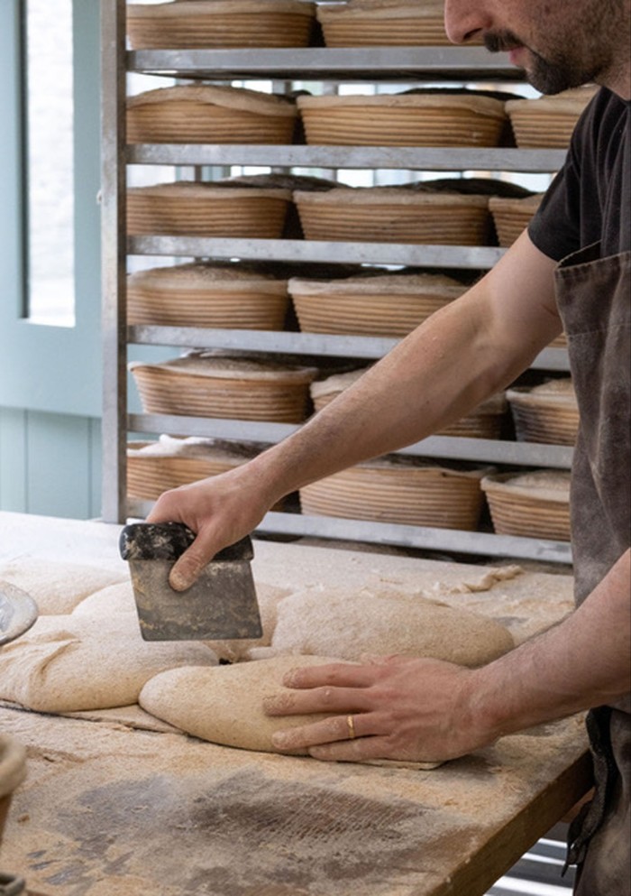 Baker Ben Glazer shapes loaves at Coombeshead Bakery in Launceston