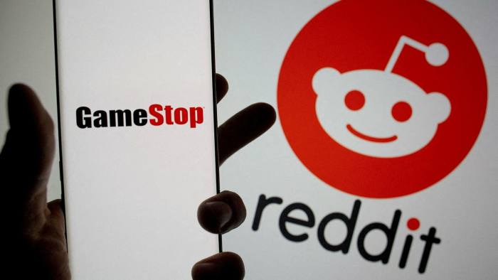  GameStop logo is seen in front of displayed Reddit logo 