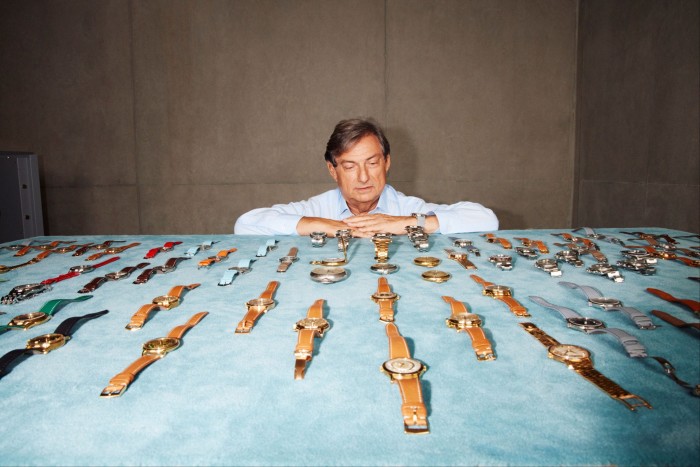 Man looking at a collection of watches displayed on a table