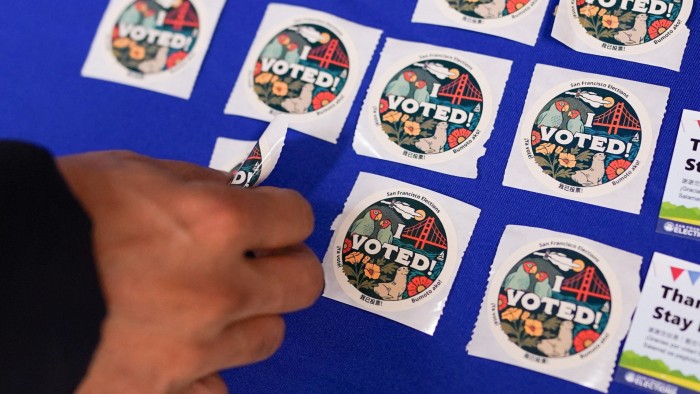 A voter takes a sticker after casting their ballot