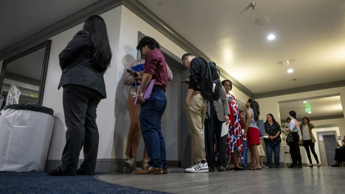 Attendees wait in line to enter the City Career Fair hiring event in Sacramento, California