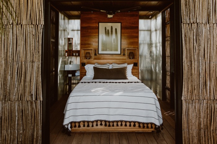 A treehouse bedroom at Acre, with hand-loomed cotton bedlinen