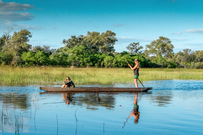 Guests travel by mokoro canoe in the Okavango Delta