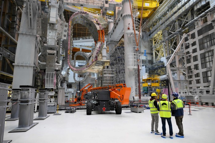 People in high-vis tops talk near a new module at the Iter fusion facility in France 
