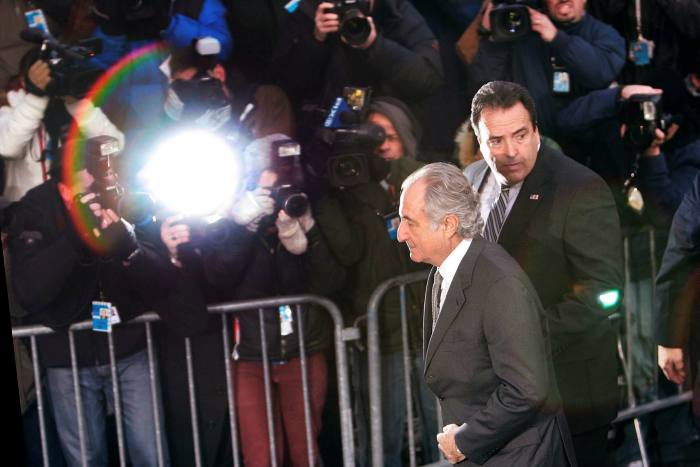 Financier Bernard Madoff passes the gathered press as he arrives at Manhattan Federal court
