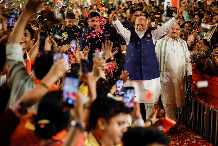 Narendra Modi waving as supporters throw confetti at BJP headquarters