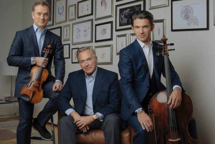 Karl-Friedrich Scheufele, co-president of Chopard, centre, sits with French musician brothers Renaud and Gautier Capuçon, holding a violin and cello