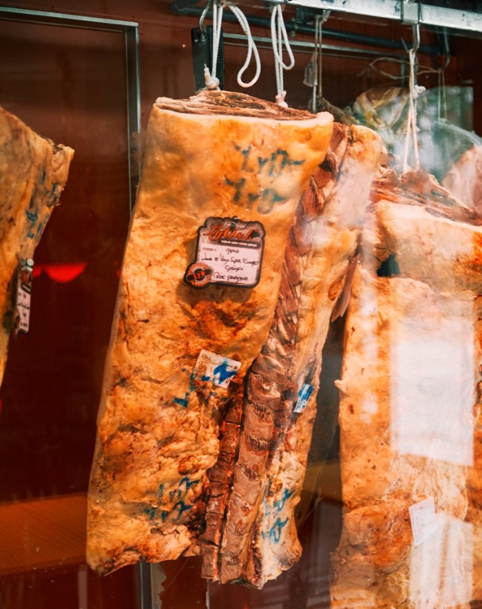 Large cuts of ham hanging from hooks at Ponzano