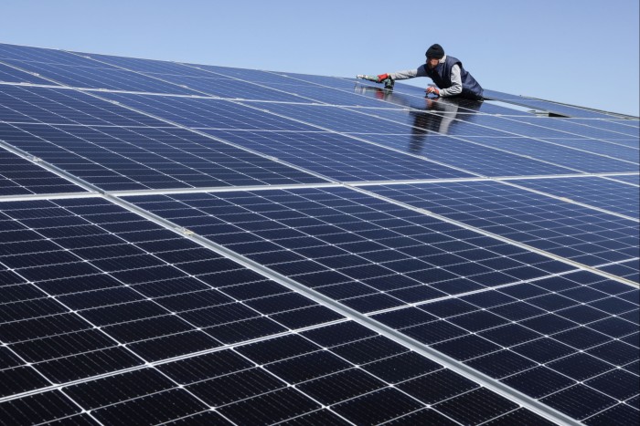 A worker installs panels at a solar park
