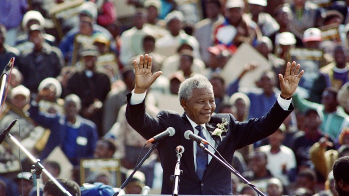 Nelson Mandela waving to the crowd surrounding him