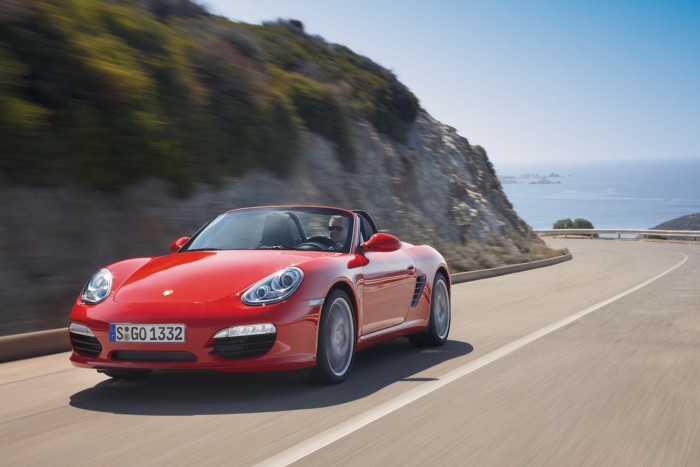A red Porsche 987 Boxster on the road