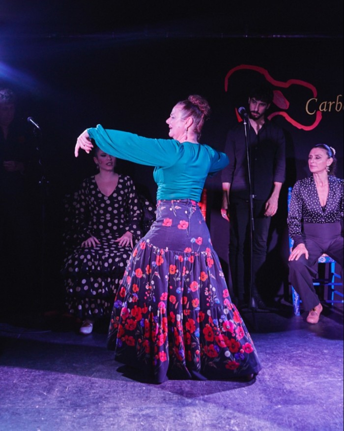 Dancer Natalia González on the stage at Las Carboneras, with other artists (including Ana Romero) behind her