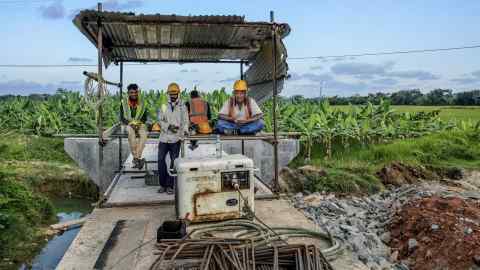 Workers take a break during construction of a highway in Sri Lanka