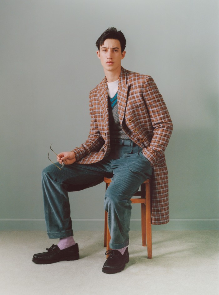 Wales Bonner wool-mix coat, £1,795, and cashmere-mix jacquard sweater vest, £468. Sunspel cotton T-shirt, £75. Loro Piana corduroy trousers, £770, and belt, £370. Manolo Blahnik leather Salcombe loafers, £675. Lindberg acetate/titanium 1177 glasses (in hand), £490. Pantherella cotton socks, £19.50