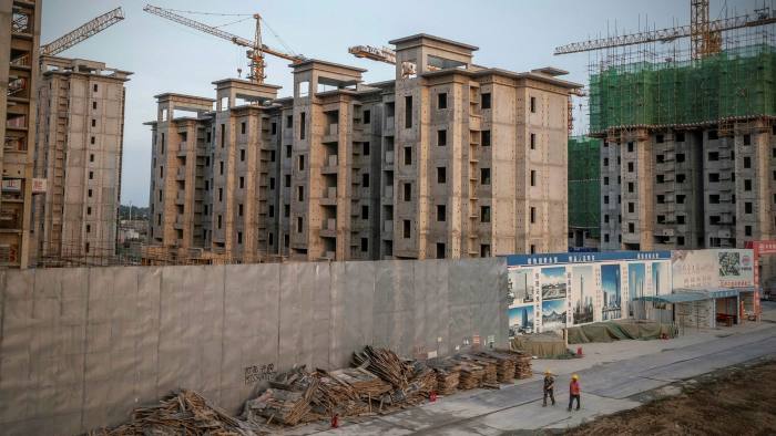 Workers leave an Evergrande residential development in Beijing in July 