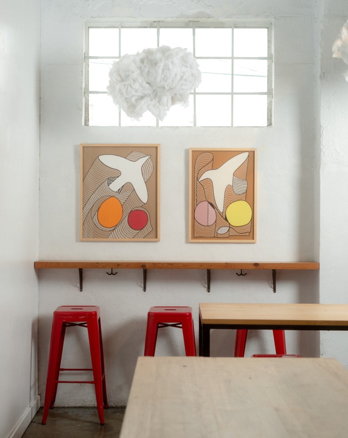 Two pieces of contemporary art featuring the outlines of birds and coloured circles on the wall at Callister’s