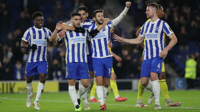 Five Brighton football players celebrating a win