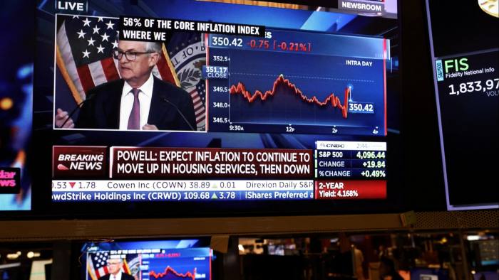 Jay Powell appears on a screen on the trading floor of the New York Stock Exchange during a news conference following a Fed rate announcement