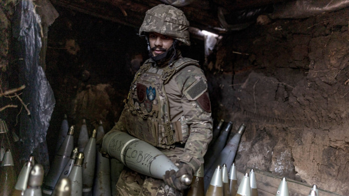 A Ukrainian soldier prepares artillery shells near the town of Lyman in eastern Ukraine