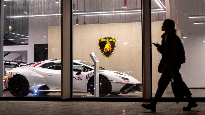 A woman walks past a Lamborghini car dealership in Moscow