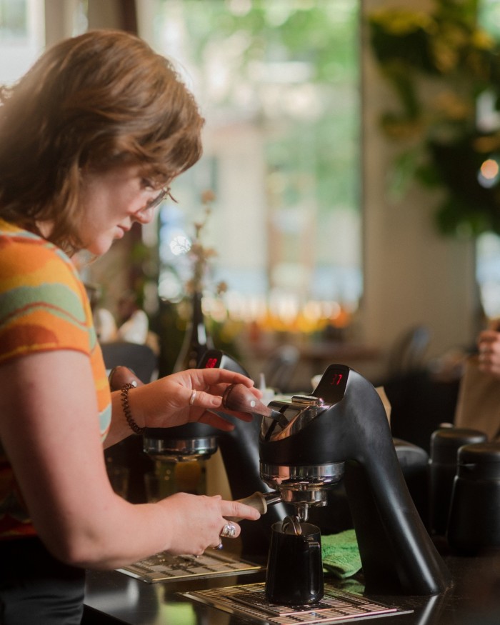 A female member of staff working with a coffee machine at Novella