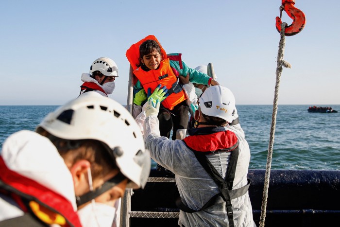 A girl cries as migrants are rescued by crew members