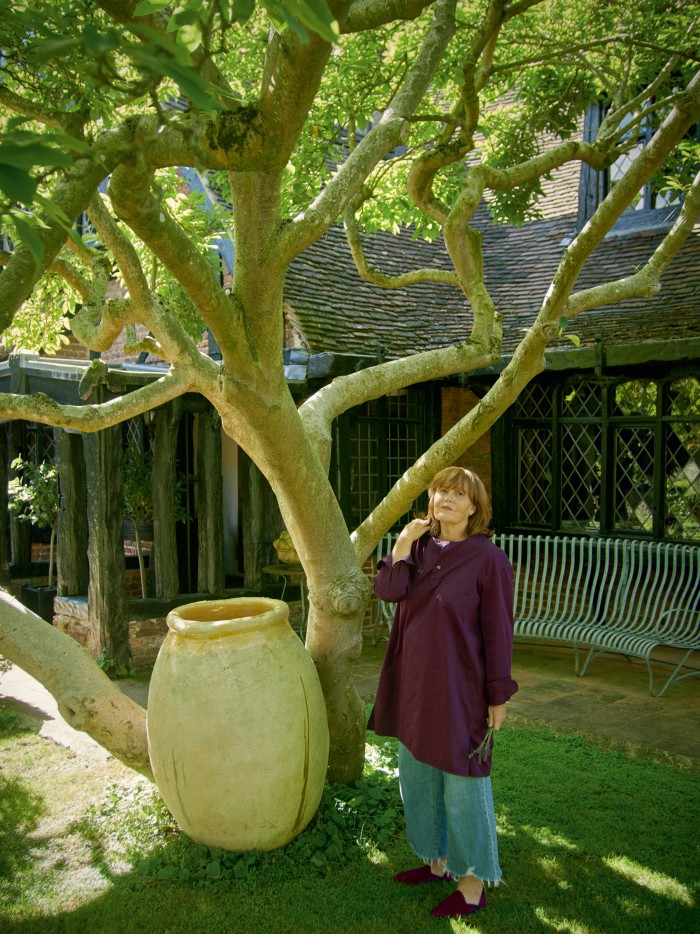 Ettedgui by a magnolia tree and an antique Andalouse pot at the entrance to her home