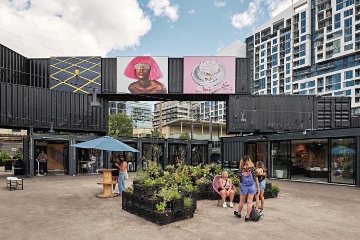  Stackt Market, a food, drink and retail space housed in old shipping containers, with  billboard-sized artworks a people queueing to get into a shop