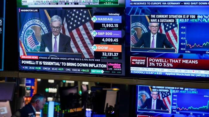 Traders watch a news conference held by Fed chair Jerome Powell 