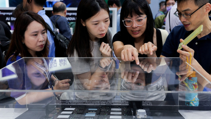 A group of people study equipment on display at Computex in Taipei, Taiwan