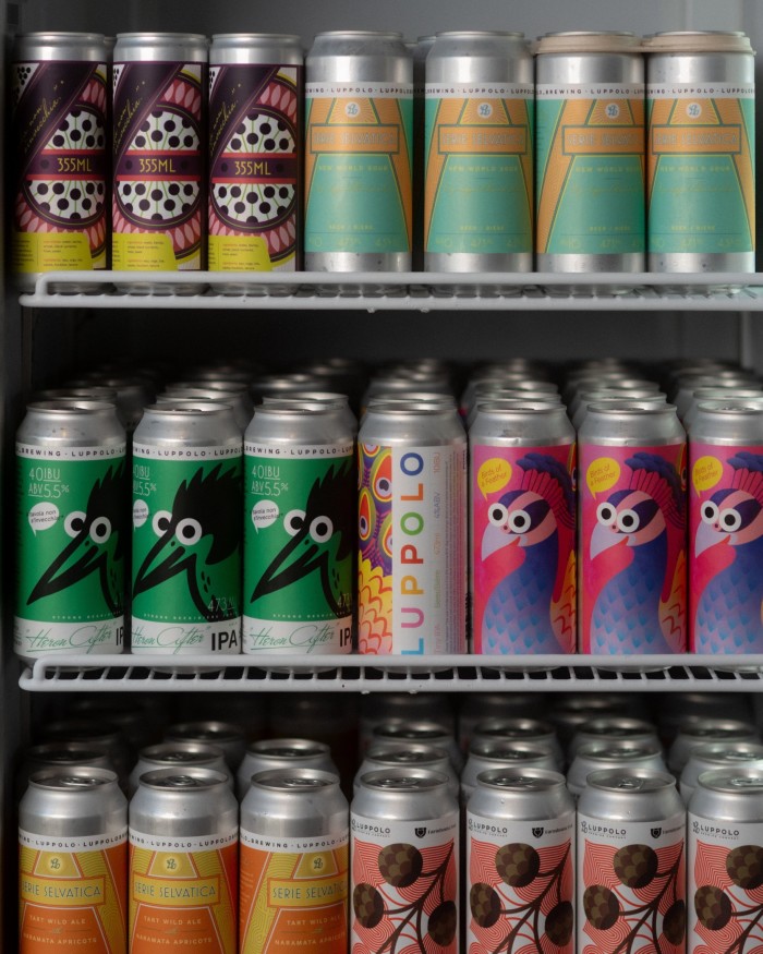 Shelves of Luppolo’s beers in colourfully illustrated cans