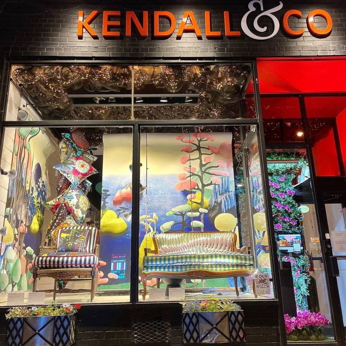 A vintage chair and sofa upholstered with contemporary patterns and prints in the colourful window display of Kendall & Co