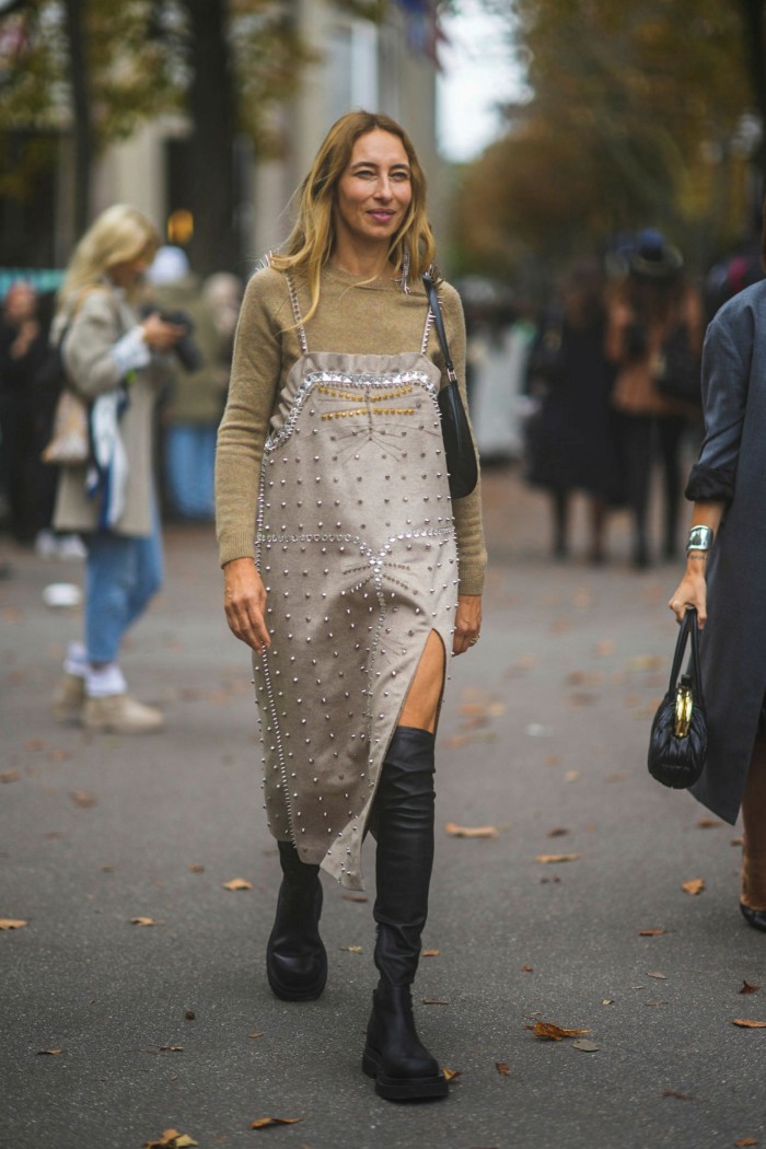 Alexandra Golovanoff in beige pullover, split midi dress and high boots outside Miu Miu 